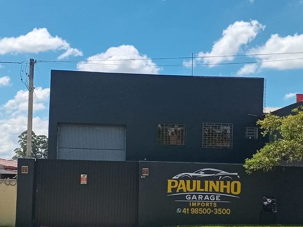 Fachada da Paulinho Imports, muro preto com o logo da oficina, na Rua Deputado Néo Martins