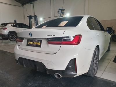 BMW 320i branco visto de trás no salão da oficina