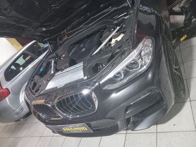 BMW X3 preto com o capô aberto e o motor à mostra