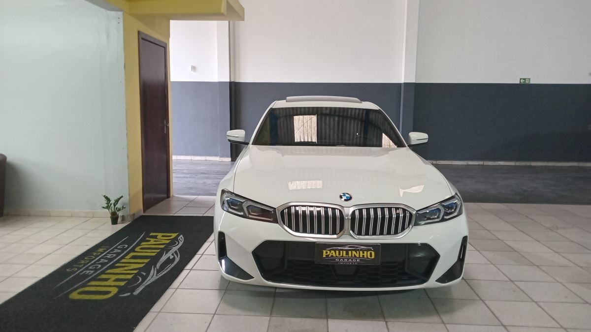BMW Série 3 branco parado sobre o tapete da Paulinho Imports, no salão da oficina