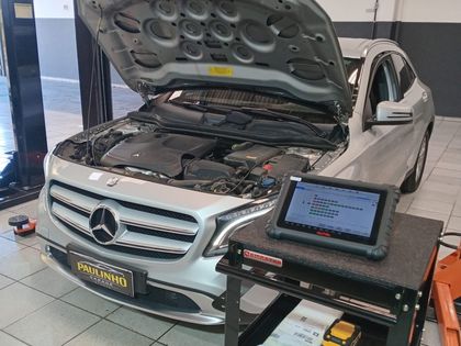 Mercedes-Benz GLA com o capô aberto e o equipamento de diagnóstico na bancada ao lado